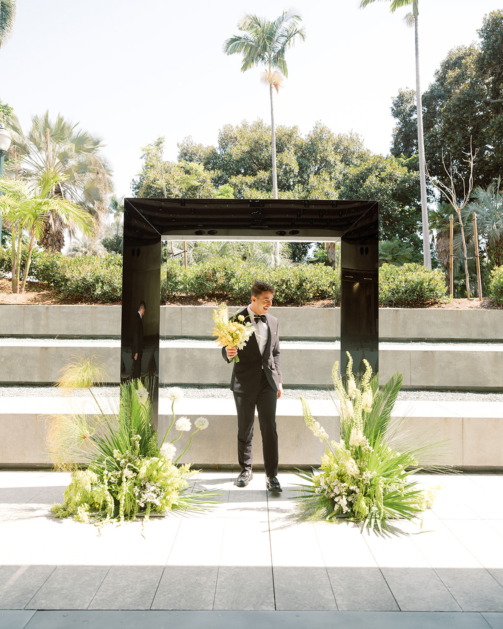 Modern black-arch wedding ceremony with lush ground florals